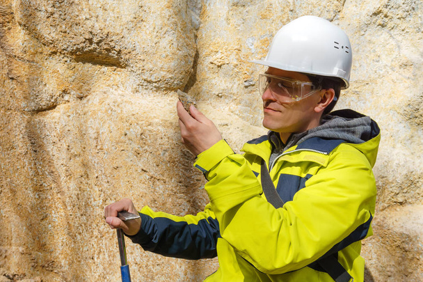 геолог досліджує зразок каменю на відкритому повітрі
 - Фото, зображення