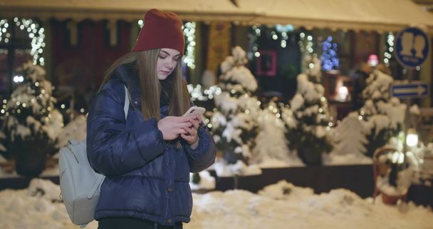 Using Mobile Phone During Walk on Streets of Night Town - Foto, Bild