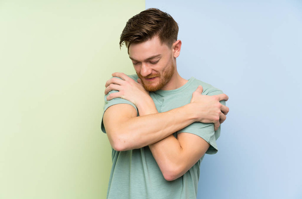 Redhead man over colorful background hugging - Photo, Image