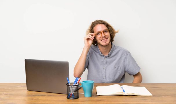 Blonde man met een laptop met bril en gelukkig - Foto, afbeelding