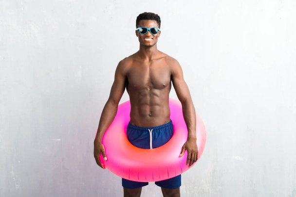 Hombre afroamericano disfrutando de vacaciones de verano con flotador
 - Foto, imagen