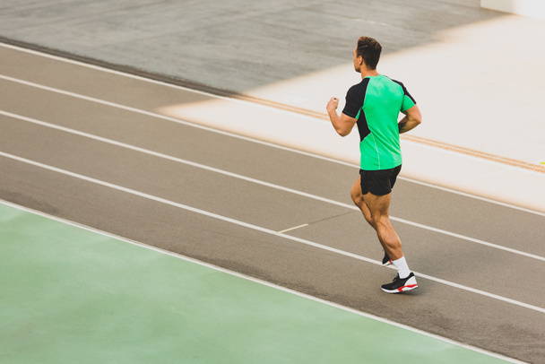 teljes hosszúságú kilátás vegyes verseny sportolója fut a stadionban - Fotó, kép
