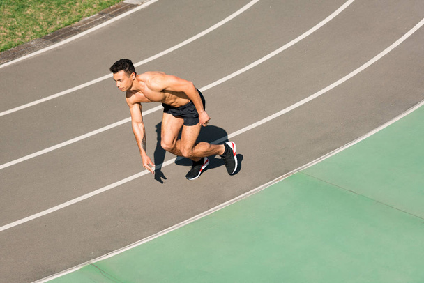 overhead view of mixed race sportsman running at stadium - Fotoğraf, Görsel