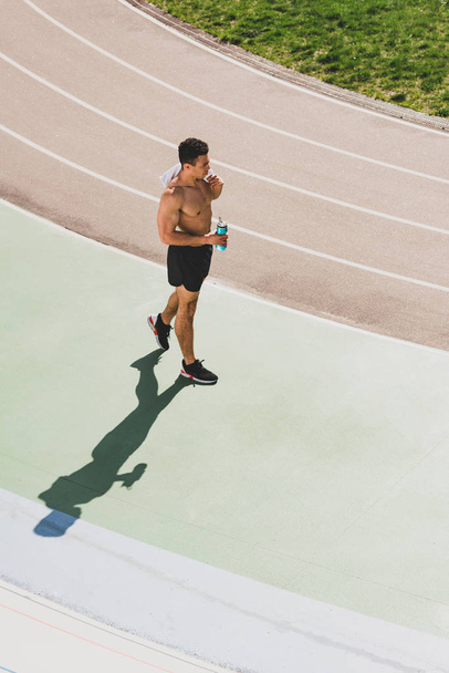 karışık yarış sporcusu tutan havlu ve stadyum spor şişe havai görünümü - Fotoğraf, Görsel