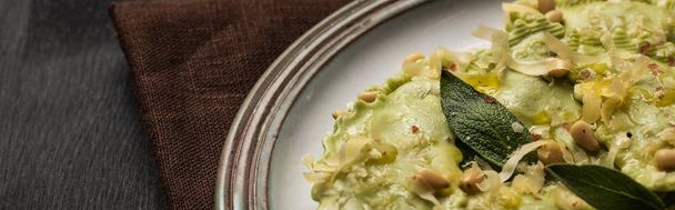 vista de perto de deliciosos ravioli verde com sálvia, queijo e pinhões, tiro panorâmico
 - Foto, Imagem