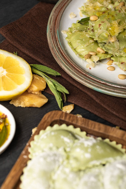 селективный фокус зеленых вкусных равиоли с кедровыми орехами на тарелке
 - Фото, изображение