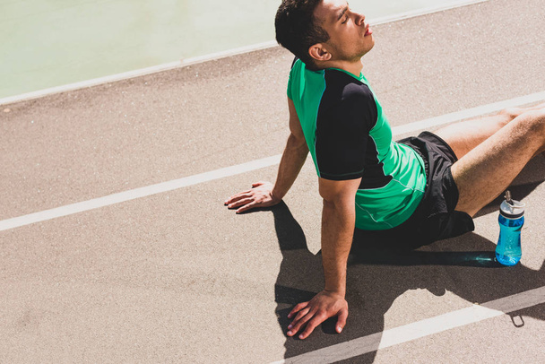unavený sportovec se smíšeným závodem sedícího na stadionu - Fotografie, Obrázek