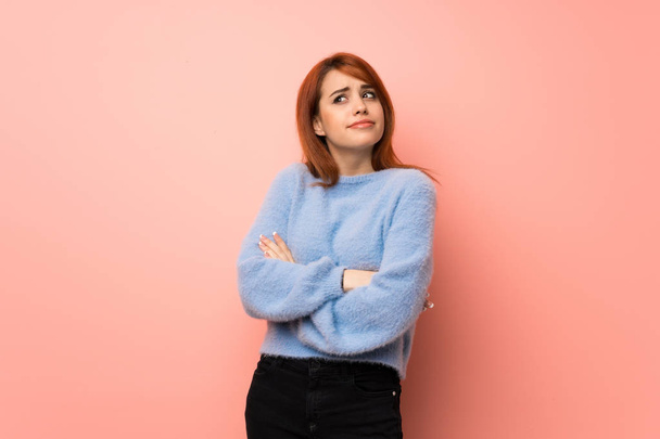 Young redhead woman over pink background making doubts gesture while lifting the shoulders - Фото, изображение