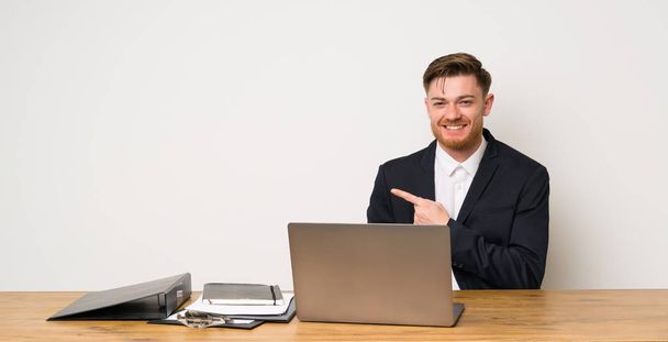 Üzletember egy irodában mutat az oldalon, hogy nyújtson be egy terméket - Fotó, kép