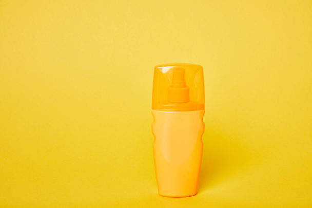 sunscreen in yellow bottle on bright yellow background - Photo, Image