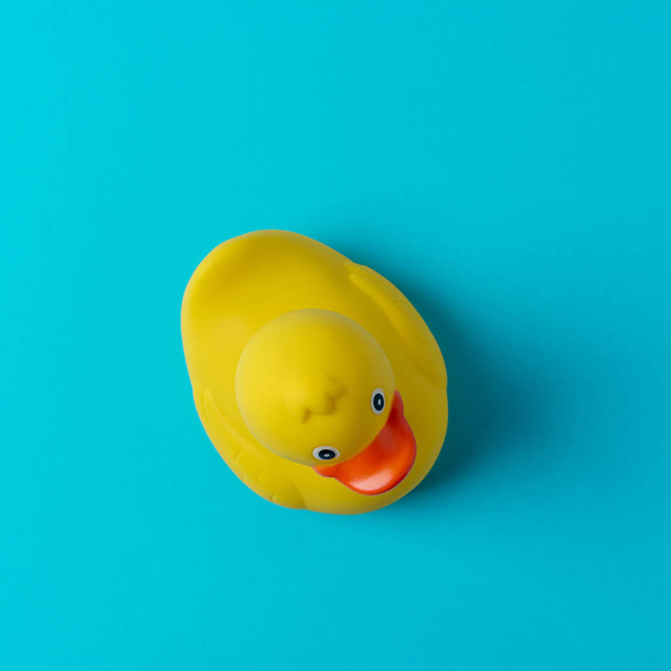Yellow rubber duck on blue background. Summer minimal concept. - Foto, Imagen
