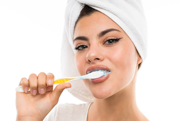 Teenager girl over isolated white background brushing her teeths - Foto, imagen