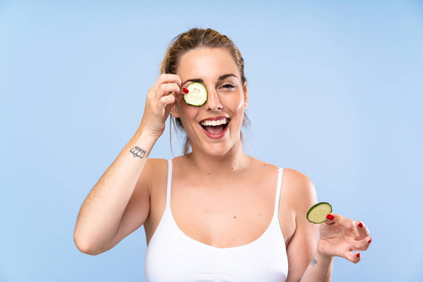 Happy Beautiful young woman holding slices of cucumber - Photo, Image