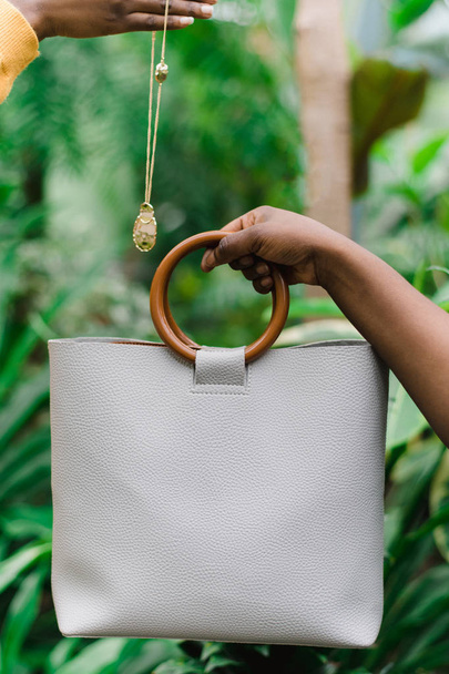 Black girls hold a bag and decoration. Green jungle background. - Photo, Image