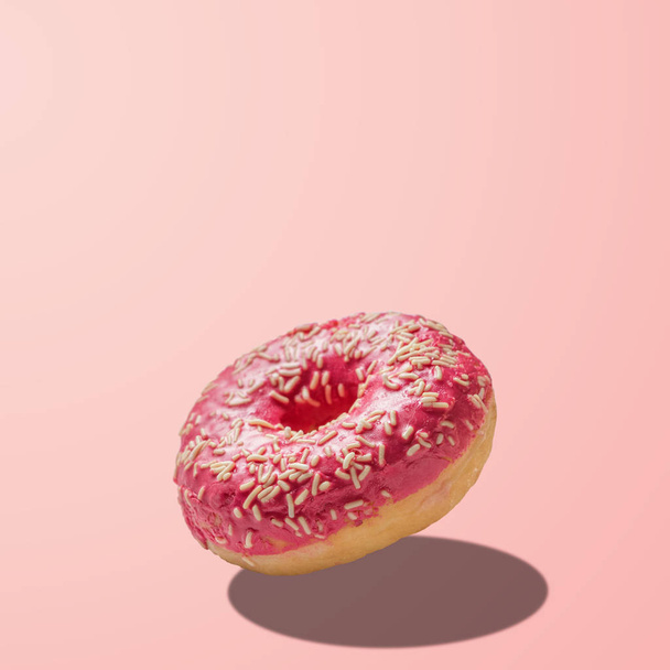Glazed donut on pastel pink background. Creative minimal concept - 写真・画像