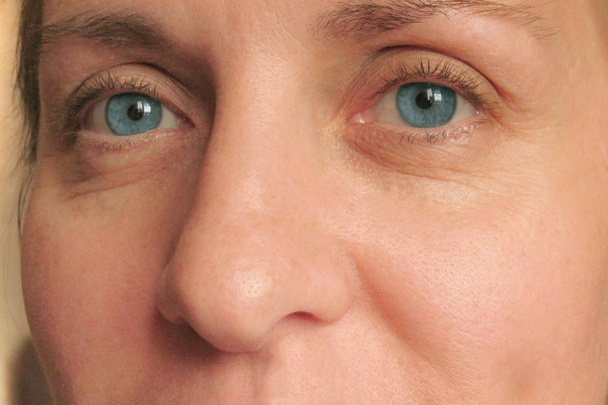 Closeup of middle aged woman face with blue eyes - Photo, Image