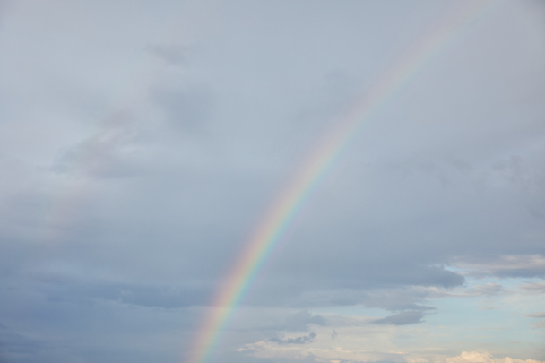 Regenbogen auf blauem Himmel Hintergrund mit Wolken und Sonnenlicht - Foto, Bild