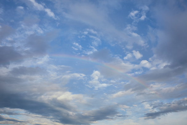 vista do arco-íris no fundo do céu azul e nuvens azuis
 - Foto, Imagem