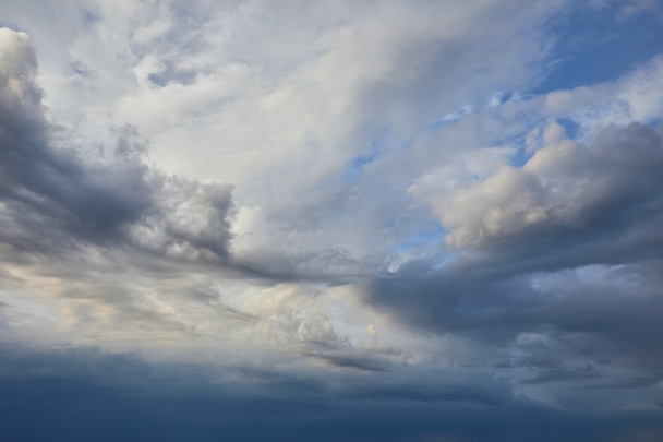vista del tranquilo fondo gris del cielo con nubes blancas y oscuras
 - Foto, Imagen