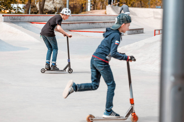 03 Maio 2019, Moscou, Rússia: Crianças montam scooters em um parque de skate em rampas e fazendo alguns truques
 - Foto, Imagem