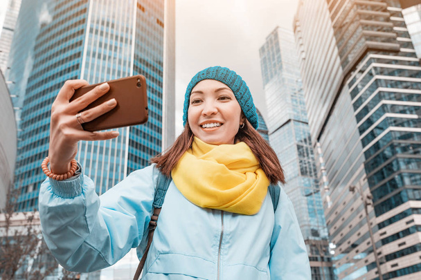 Joven asiático mujer tomar selfie foto en frente de rascacielos
 - Foto, imagen