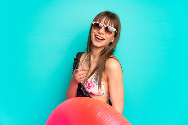 jonge vrouw in bikini over blauwe muur wijst vinger naar u - Foto, afbeelding