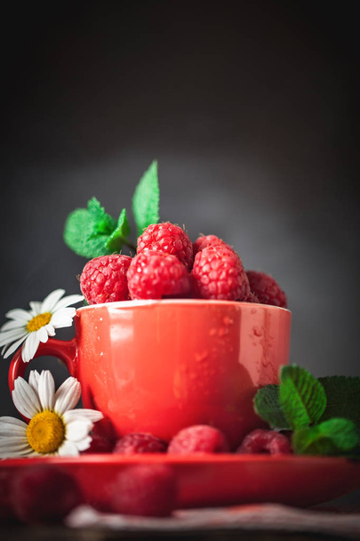 Raspberry. Raspberries in a Cup on a dark background. Summer and healthy food concept. Background with copy space. Selective focus. - Photo, Image