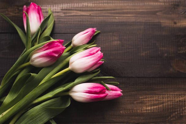 Čerstvé nádherné růžové tulipány na dřevěné tmavé pozadí s prostorem pro kopírování - Fotografie, Obrázek