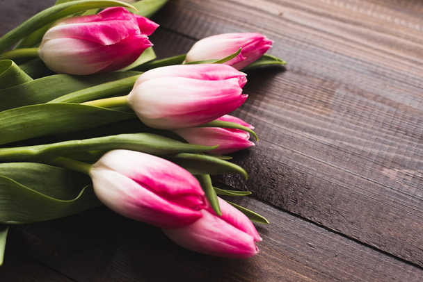 Friss gyönyörű rózsaszín tulipánok egy fából készült sötét háttér másolási tér - Fotó, kép