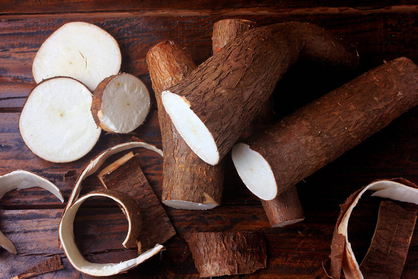 fresh cassava and peels and slices on rustic wooden table - Foto, Bild