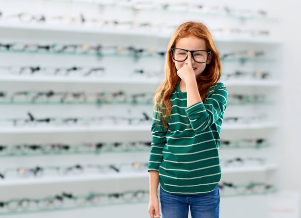 red haired student girl in glasses at optics store - Photo, image