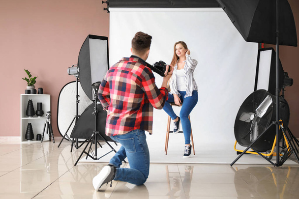 junger männlicher Fotograf arbeitet mit Model im Studio - Foto, Bild