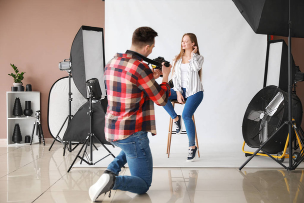 Jonge mannelijke fotograaf werkt met model in studio - Foto, afbeelding