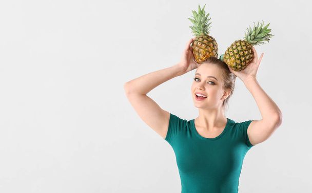 Zabawna młoda kobieta z ananasów na białym tle - Zdjęcie, obraz