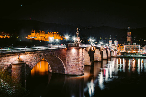 Heidelberg várospanoráma a Neckar folyó mellett éjjel, Baden-Wurttemberg, Németország - Fotó, kép