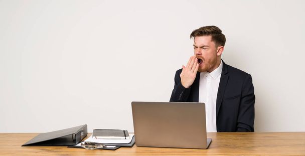 Бізнесмен в офісі позіхання і покриття широкий відкритий рот рукою
 - Фото, зображення
