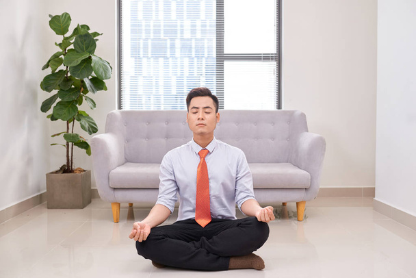 Biznesmen medytacji w pozycji lotosu, na podłodze w biurze  - Zdjęcie, obraz