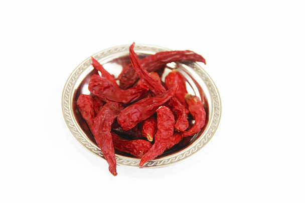 a szárított vörös forró étkezési paprika hüvelye fehér alapon fémlemezen - Fotó, kép