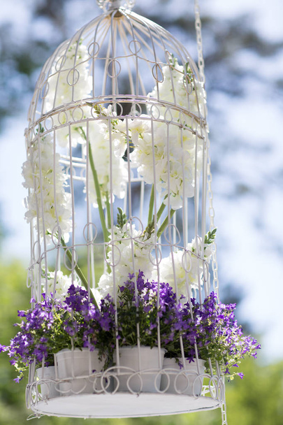 Decoración de la boda con flores lila y jaulas blancas
 - Foto, imagen