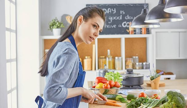 Uma jovem prepara comida na cozinha. Alimentos saudáveis - vege
 - Foto, Imagem