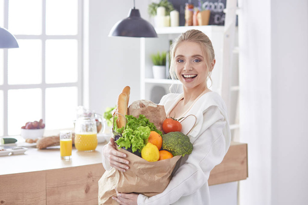 jonge vrouw met kruidenier boodschappentas met fruit di - Foto, afbeelding