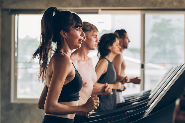 Young Caucasian sporty group of men and women running on treadmill in gym - Foto, Imagen