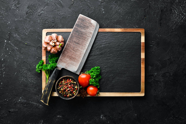 Kitchen board and spices. Banner On a black stone background. Top view. Free space for your text. - Fotografie, Obrázek