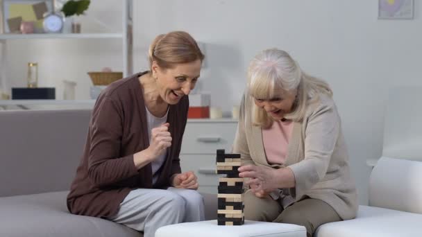 Elderly females playing block game having fun in nursing home, retirement hobby - Metraje, vídeo