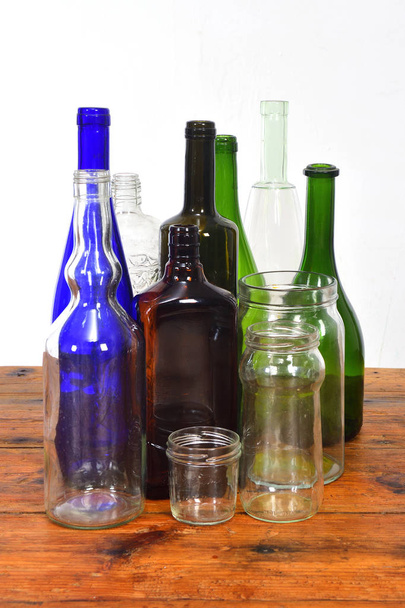 gruppo di bottiglie e barattoli di vetro su un tavolo di legno con bac bianco
 - Foto, immagini
