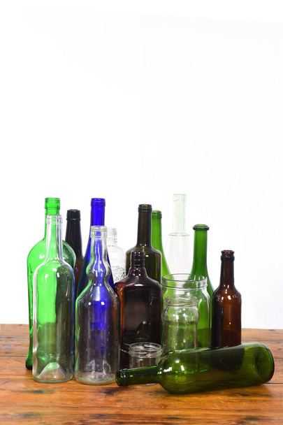 group of bottles and glass jars on a wooden table with white bac - Photo, Image