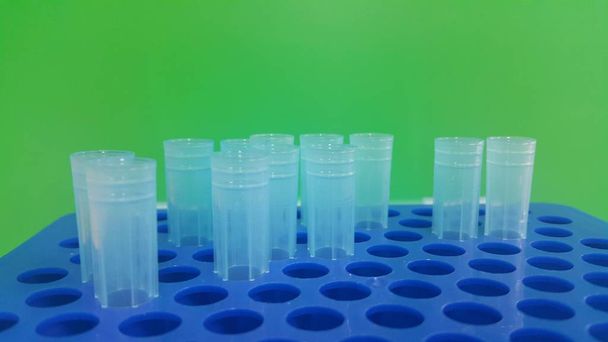 Vue rapprochée des embouts micro-litres bleus dans une boîte à micro-embouts avec trous vides
. - Photo, image