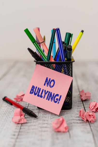 Writing note showing No Bullying. Business photo showcasing stop aggressive behavior among children power imbalance Writing equipment and paper scraps with blank sheets on the wooden desk. - 写真・画像