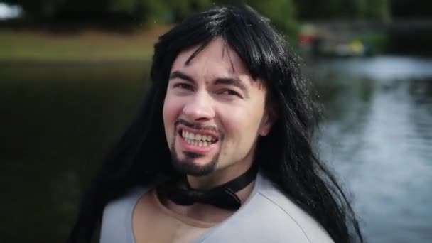 Attractive bearded guy with long hair and fake muscle costume sings outside. - Footage, Video