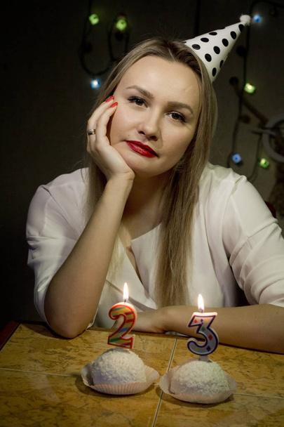 Holka, co má narozeniny, vyžene svíčky na dortu ve tmě. - Fotografie, Obrázek